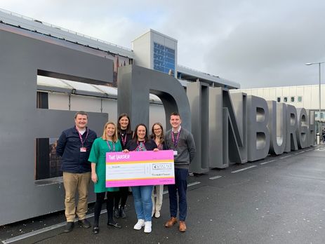 Team posing with donation cheque for The Larder charity