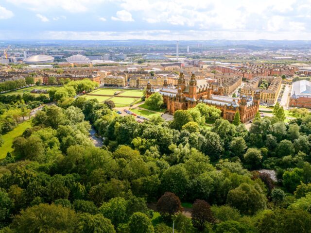 Image of Kelvingrove museum from above surrounded by trees.